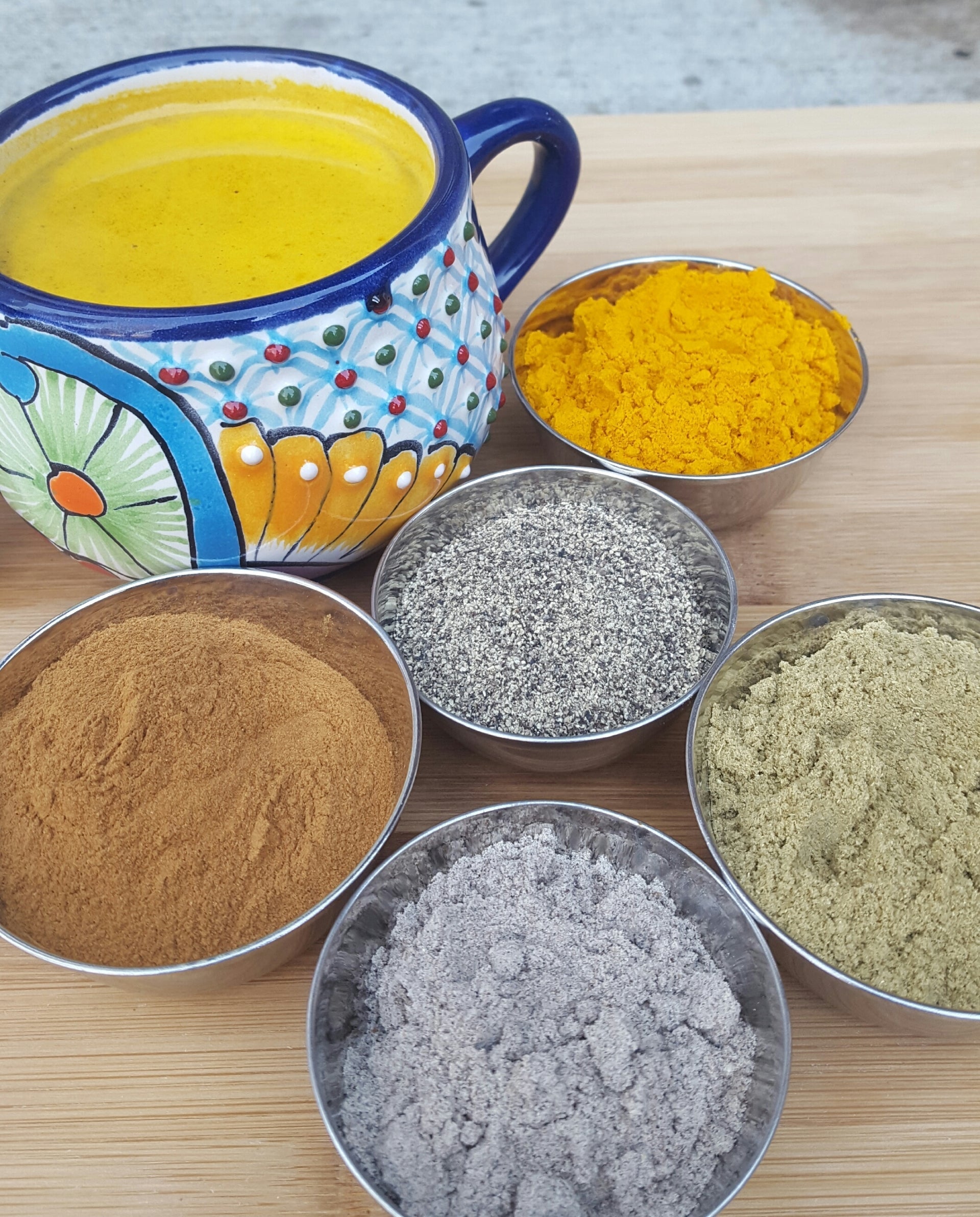 Leely Chai Co.’s golden turmeric latte served in a handcrafted mug alongside turmeric, cinnamon, black pepper, and spices.
